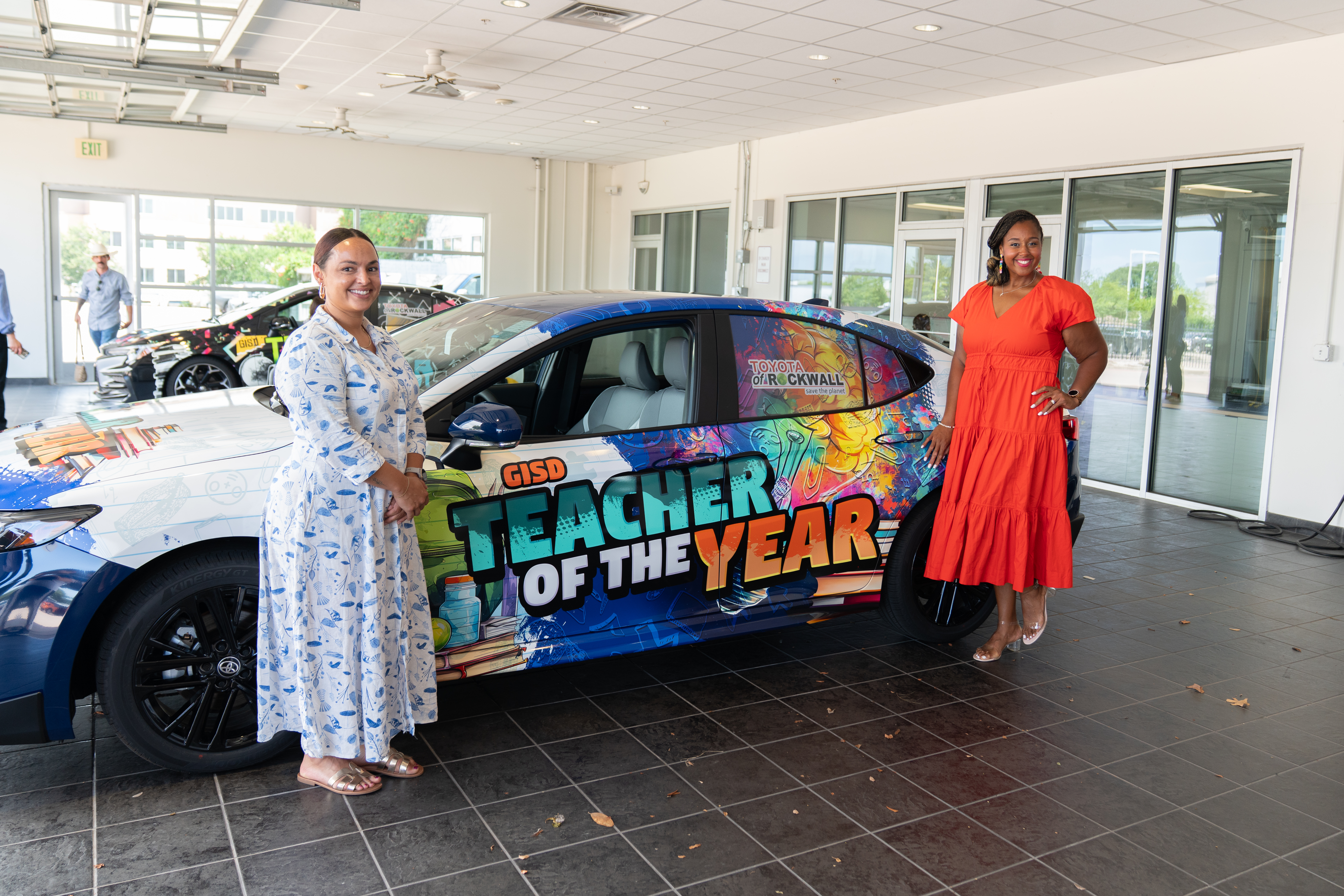 Ashley Ross stands in front of a car wrapped with GISD Teacher of the Year