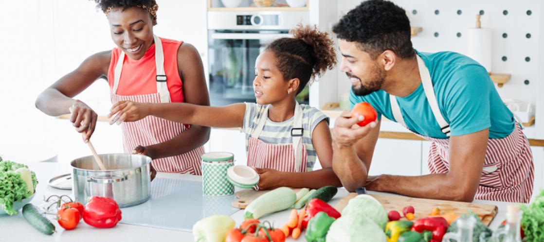 family of three prepares a healthy meal together