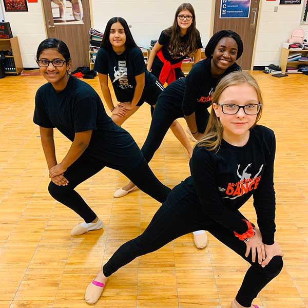 Five middle school girl dancers posing in dance formation.