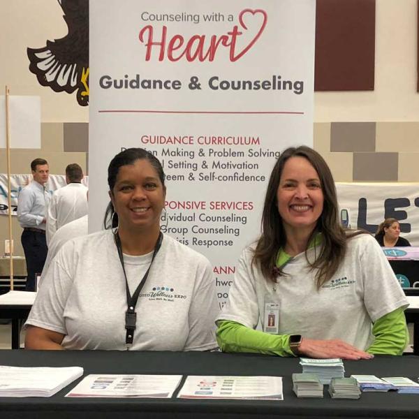 Two counselors sitting at a table with resources