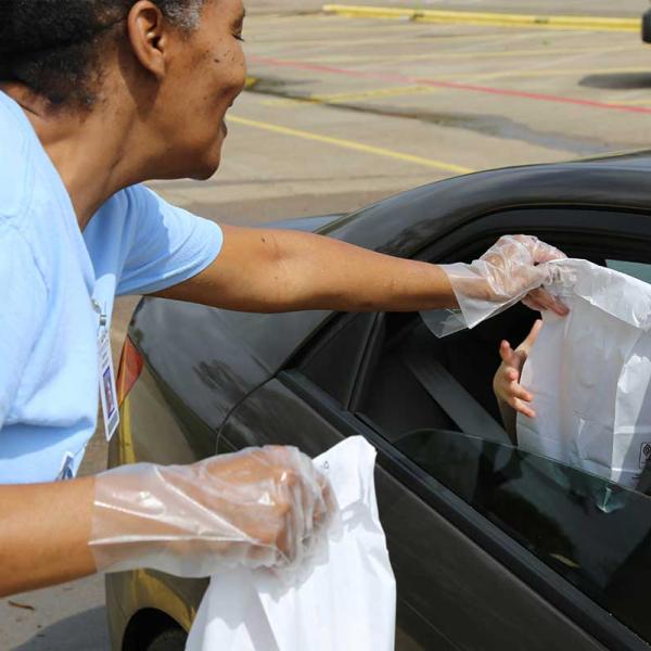 A GISD volunteer handing out food