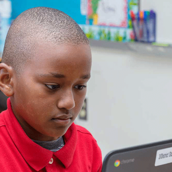 A young boy focused on a laptop