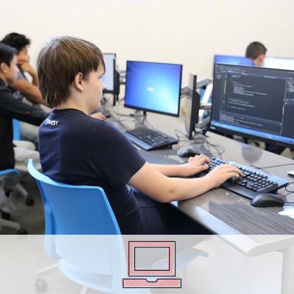 A student coding with several others. A computer icon representing the information technology cluster is overlaid on the image.