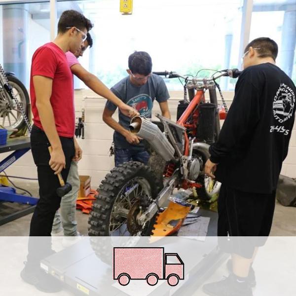 Students working on repairing a motorcycle. A truck icon representing the Transportation cluster is overlaid on the image.