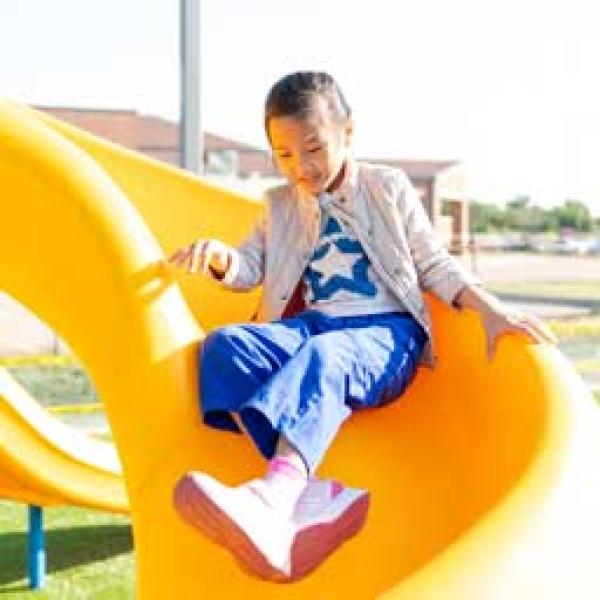 Girl on slide in new playground from Bond 2023 project