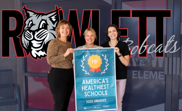A group of three women stand with a banner that reads "America's Healthiest Schools"
