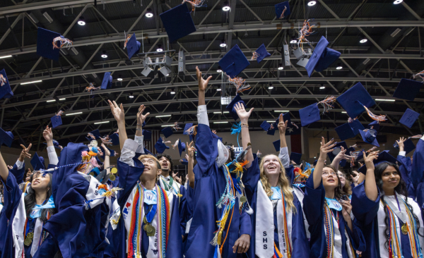 students throw their graduation caps in the air