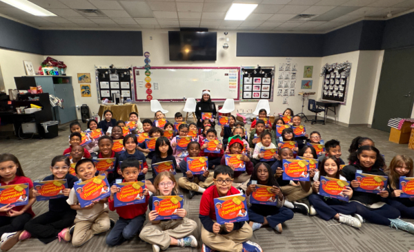 A group of students pose with their books