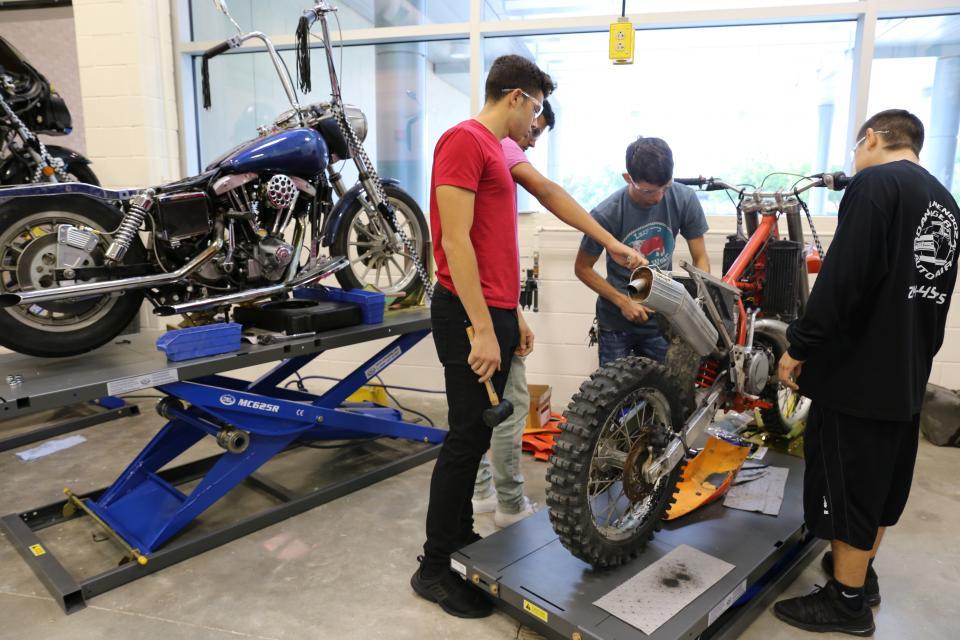 Students working on repairing a motorcycle