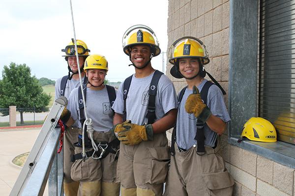 Several student from our firefighting class posing in gear at the practice building.