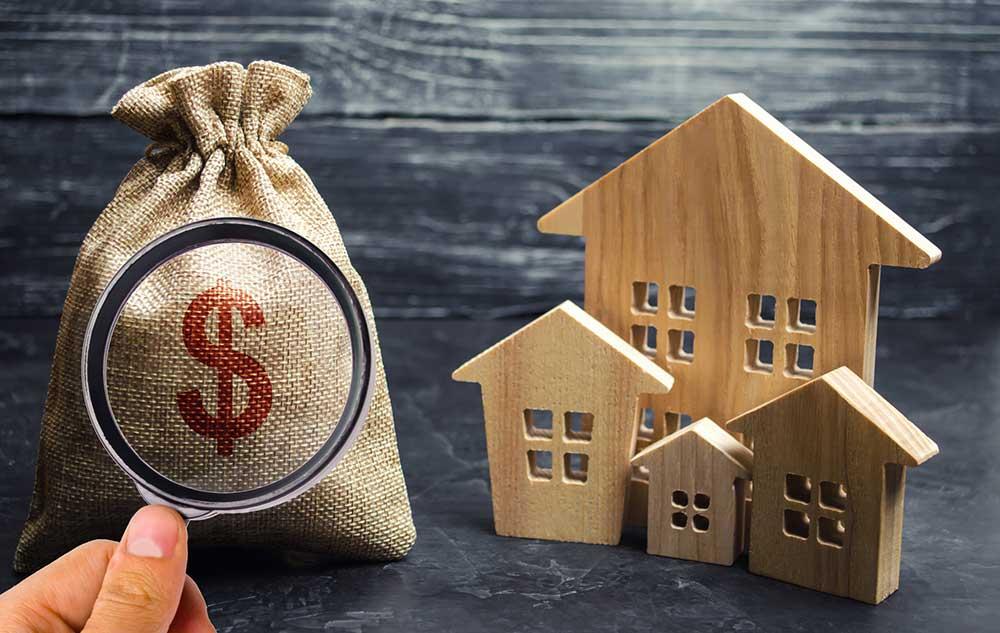 Money bag next to wooden houses