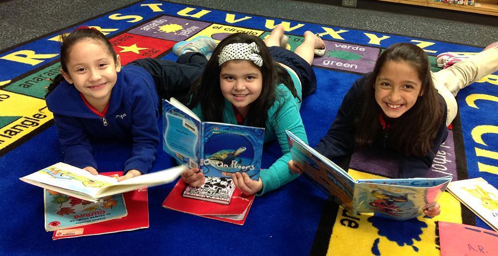 Three girls smiling with books 