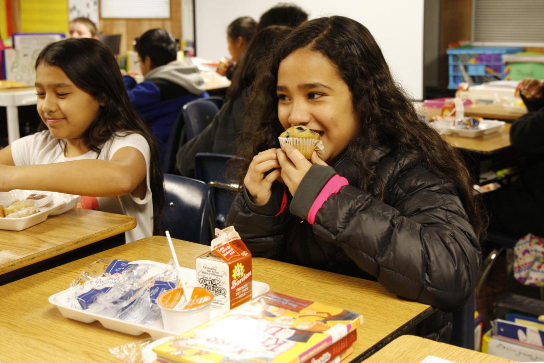 Student eating muffin for breakfast in the classroom