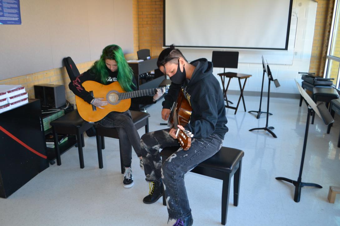 High school students practicing guitar