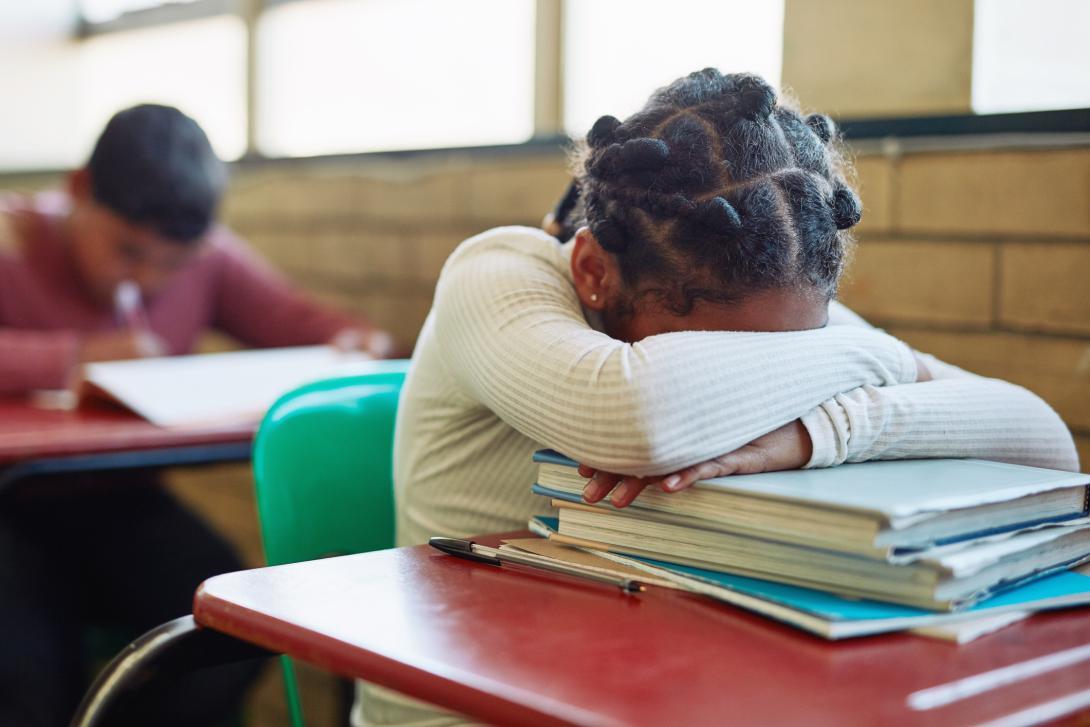 A student at her desk with her head down