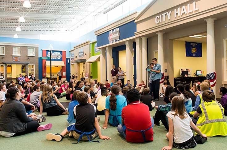 Students sitting outside of city hall in BizTown.