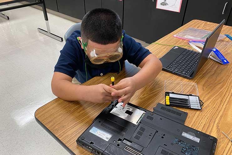 Student works on fixing computer