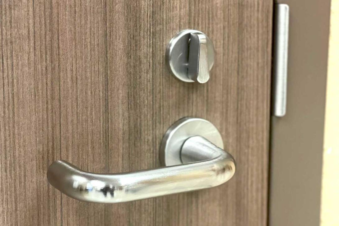 Close up of ADA-compliant door handle with lock.