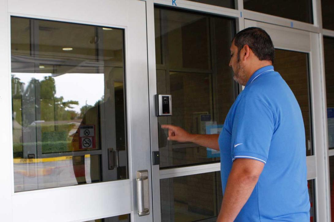 Man using intercom at campus entrance