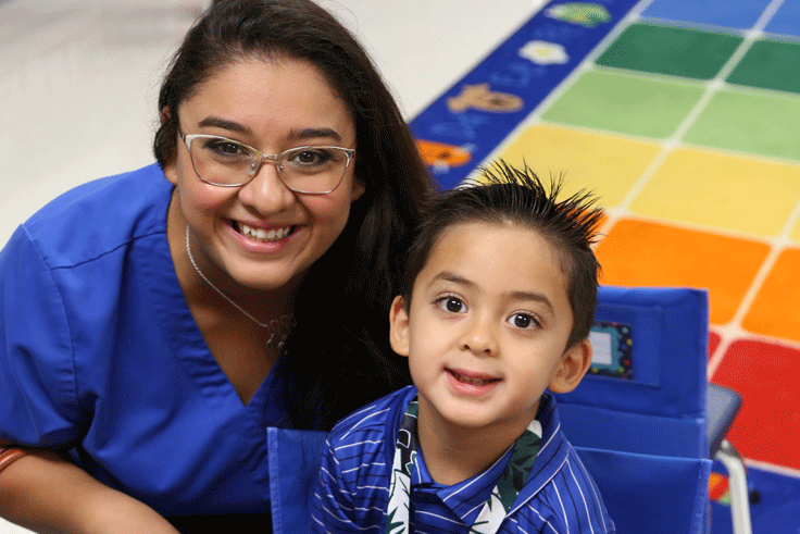 A mother and her son posing in the Pre-K classroom