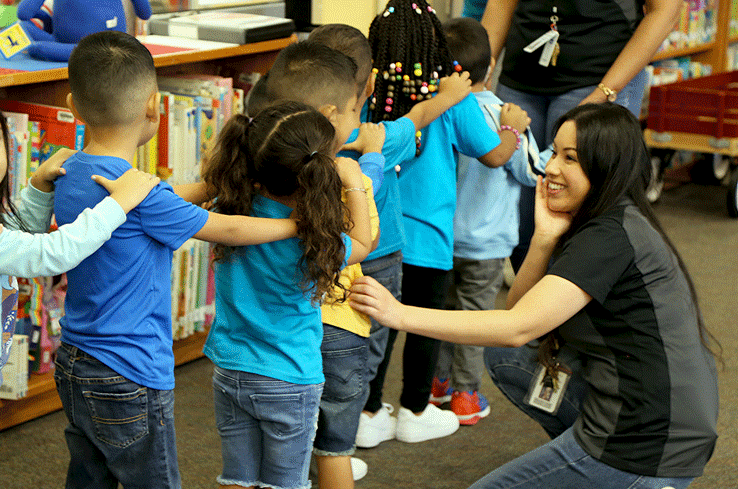 A teacher talking and smiling to her students as they line up