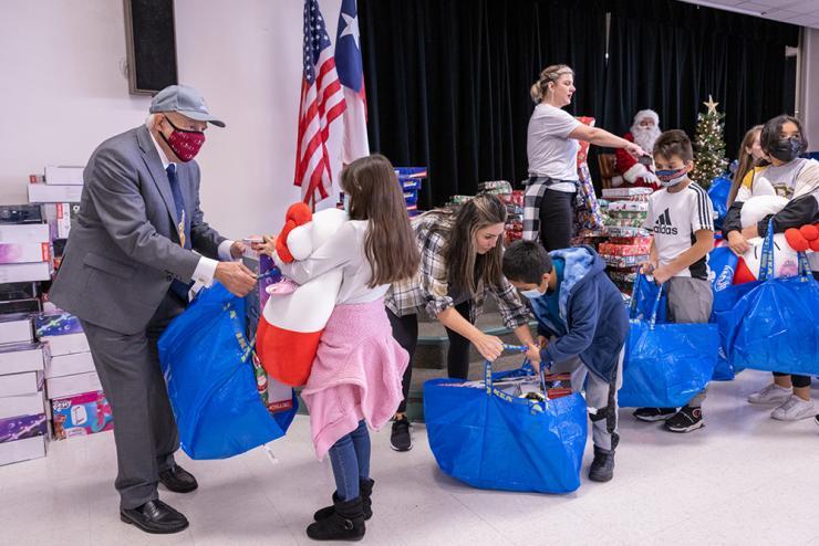 Staff and board trustees hand out donated gifts