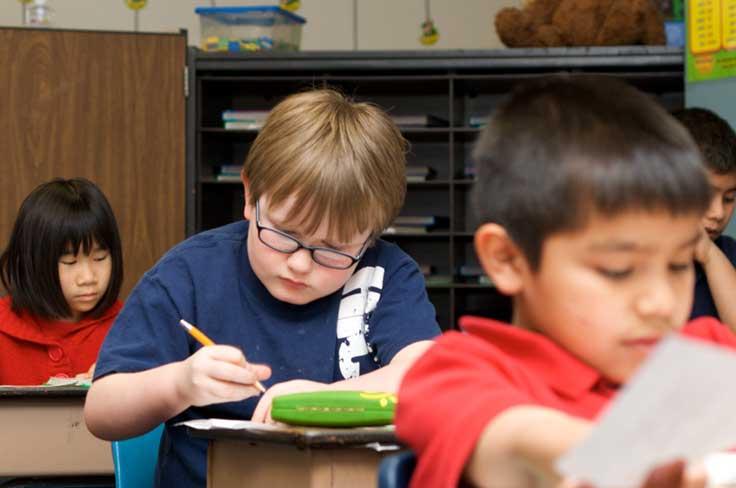 elementary boy focused on school work at desk