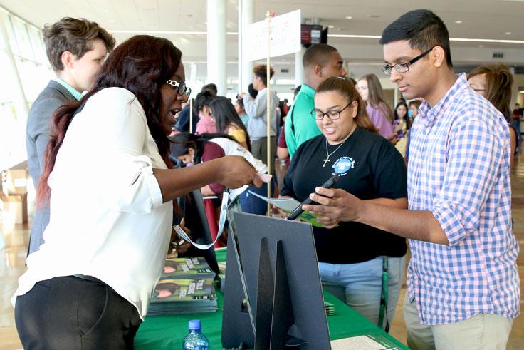 Two college advisers talking to interested students