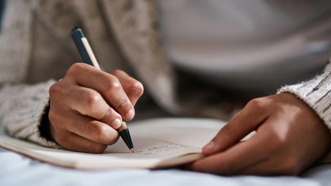 A person taking notes in a notebook