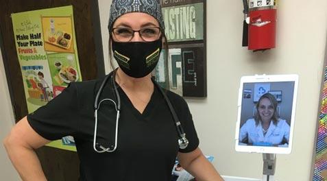A nurse posing next to a telehealth nurse on an iPad.