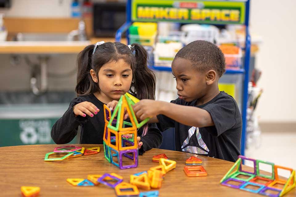 Two elementary students collaborate on building a tower using Maker Space materials.