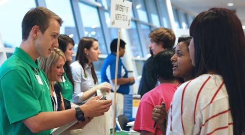 Students crowded around a UNT representative's table asking questions.