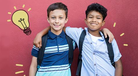 Two young boys with backpacks giving each other a side hug and smile, with an illustrated linear lightbulb glowing next to them.