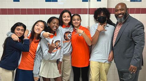 The Coyle principal posing with several students.