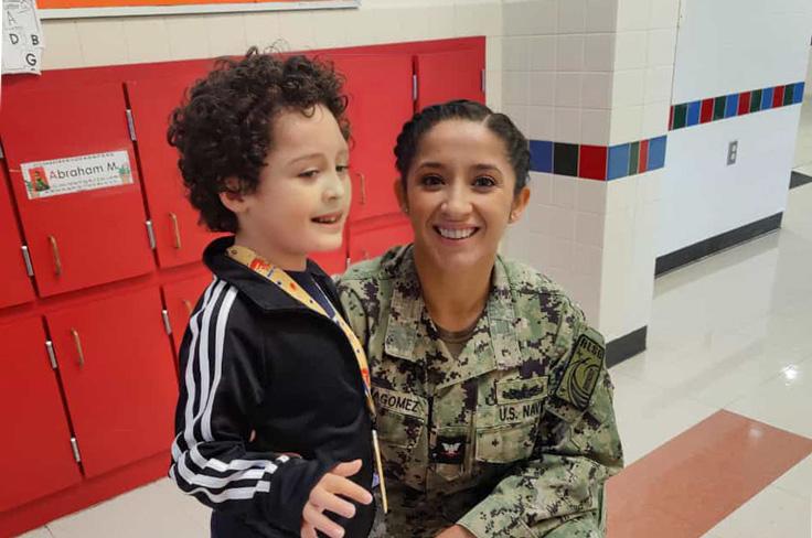 A U.S. Navy member posing with a prekindergartner at Parsons Prekindergarten.