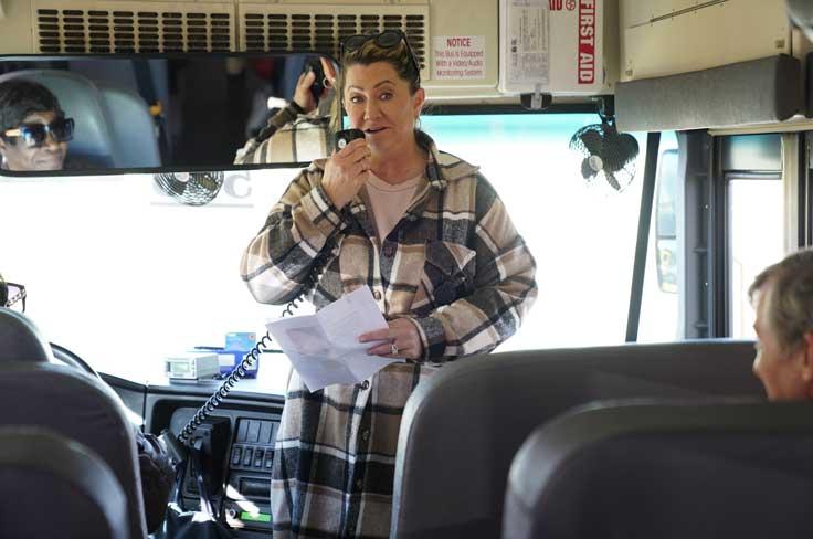 Woman greets bond steering committee members on a bus before leaving for facility tours.