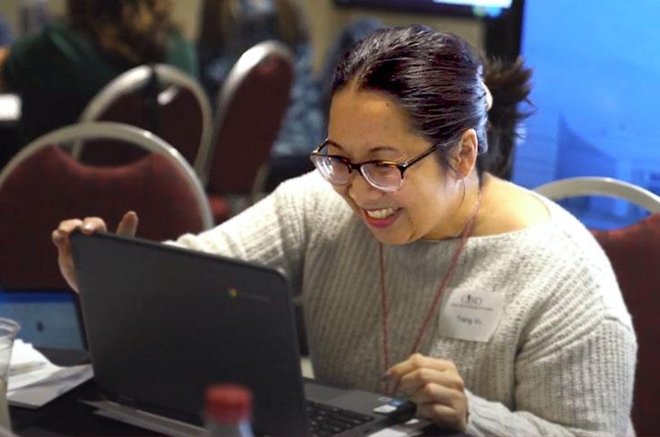 A woman using her laptop to submit her vote for the ballot options.