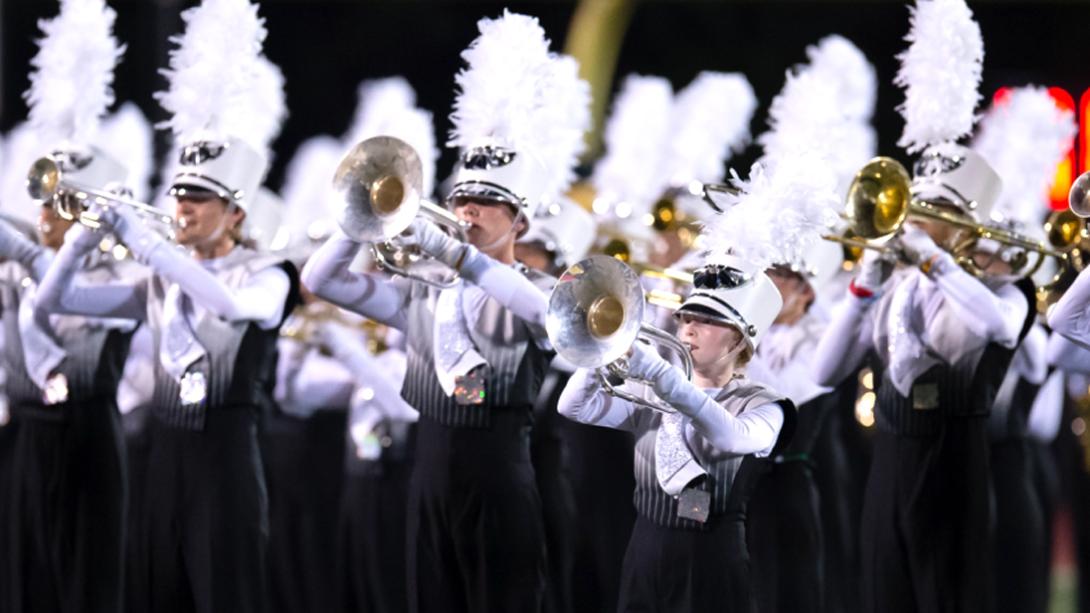 A GISD Band performing their marching routine on a football field.