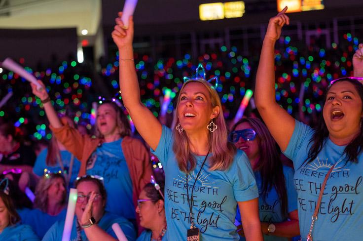 Teachers wave neon light sticks in excitement during the annual convocation ceremony.