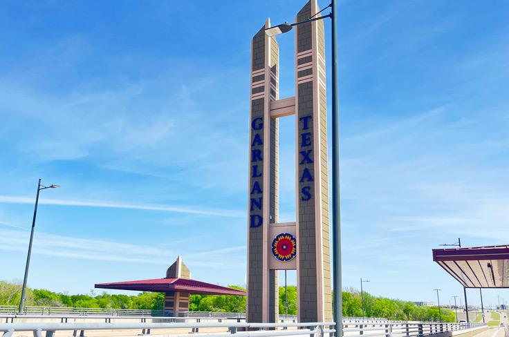 The Pleasant Grove bridge in Garland, sporting two tall green and tan towers in the shape of an "H" and Garland's Firewheel Flower logo.