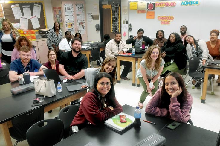 Teachers posing at desks during a Project Goal gathering.