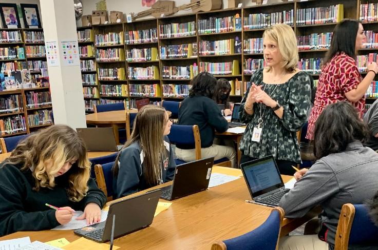 Teacher leading students in library lesson