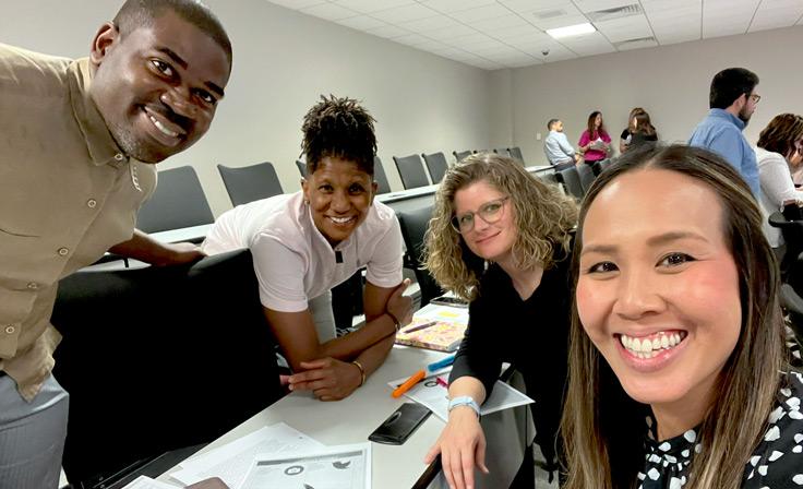 A group photo of several current employees smiling while at professional development.