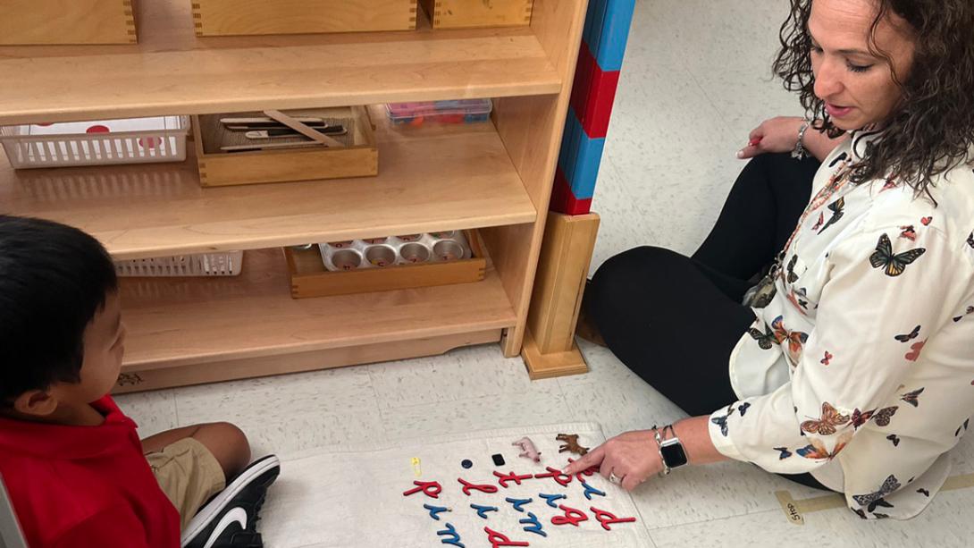 A Montessori teacher working with a child using manipulatives.