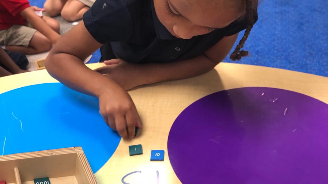 A student using tiles to count to the number 13.