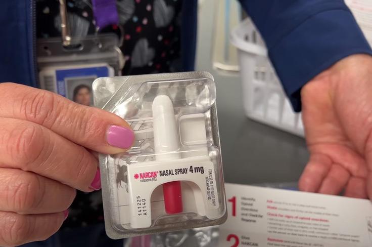 An up-close shot of a GISD Nurse holding a package of Narcan and a set of instructions.