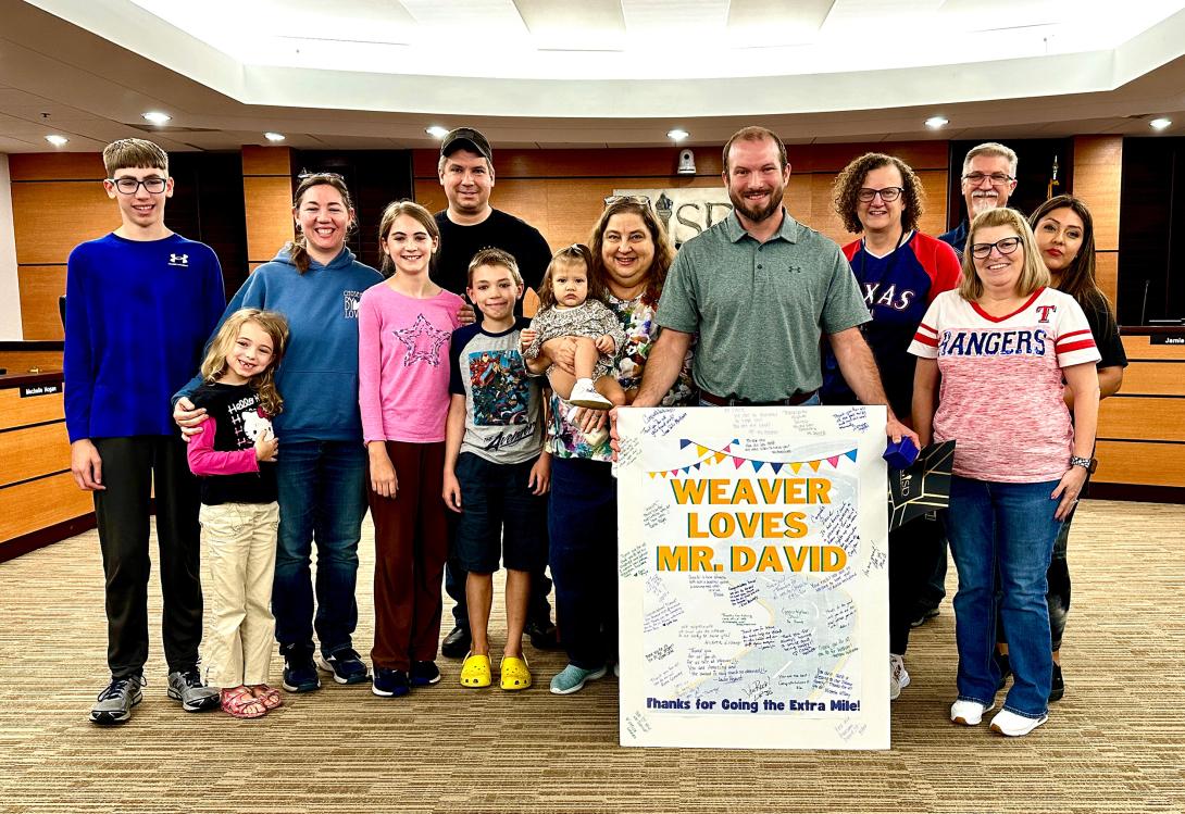 WEaver Elementary Custodian Standing with his family after receiving an award from GISD at the School Board meeting