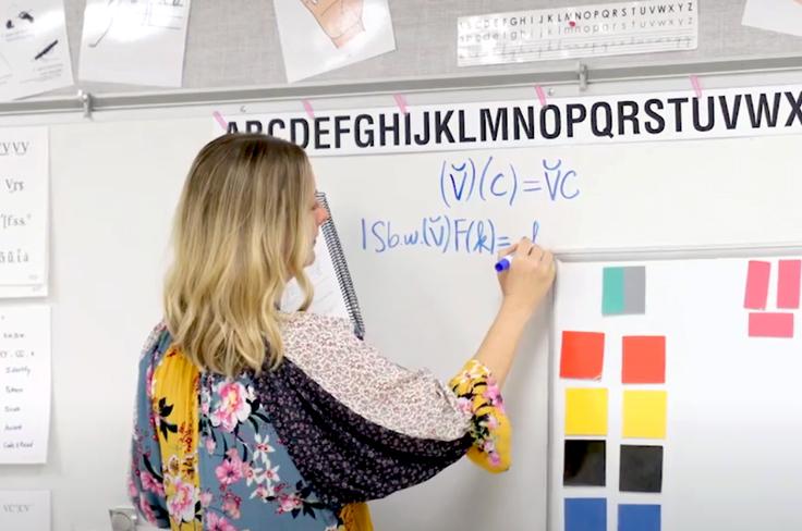 A dyslexia teacher breaking words down on a white board, with post it note blocks to help visualize stuck to the board.