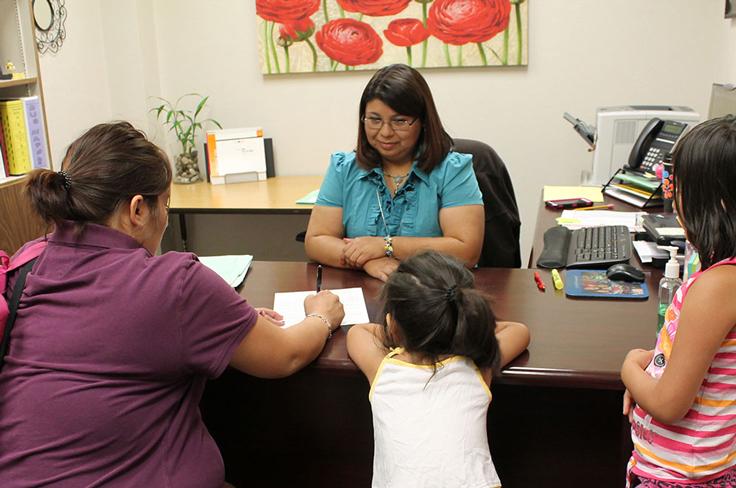 A counselor speaking with a mother and her daughters.