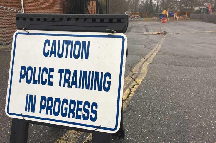 Sign outside of a building that says "Caution: Police Training in Progress"